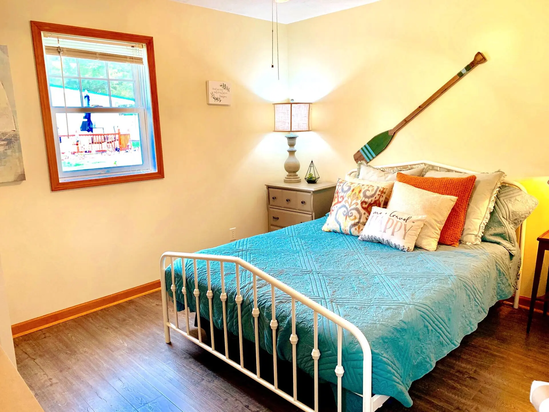 Bedroom with a metal bed frame and colorful lake-themed bedding